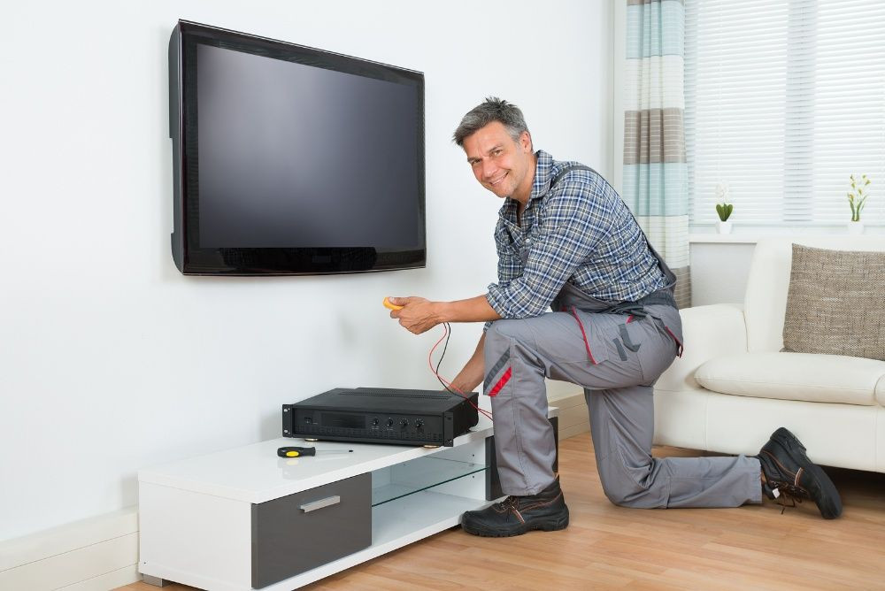 man kneeling and installing DStv